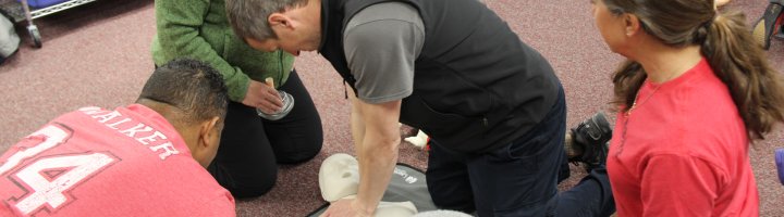 Instructor Lester Stoltz teaches a small group how to perform CPR.